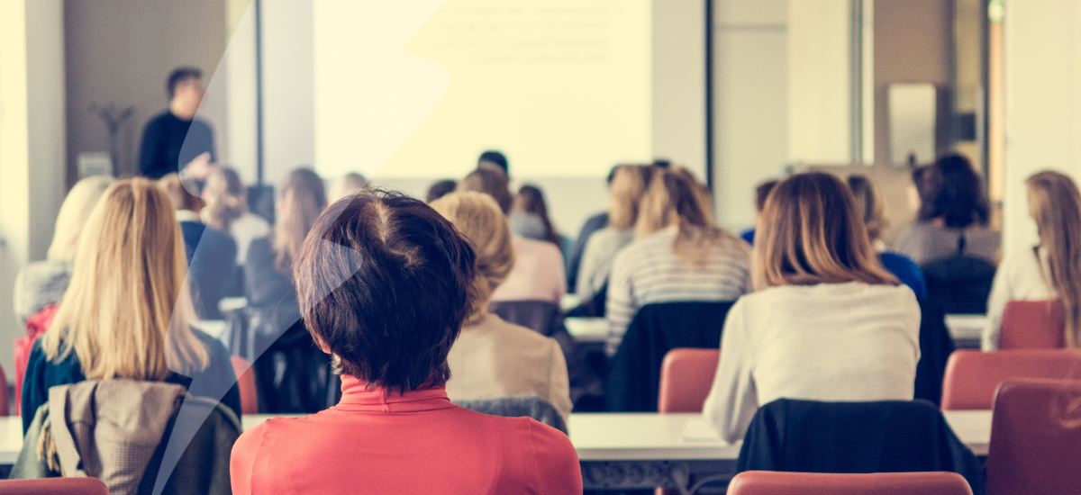 Image of attendees in a conference hall.