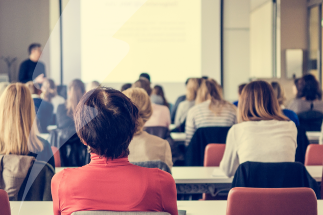 Image of attendees in a conference hall.